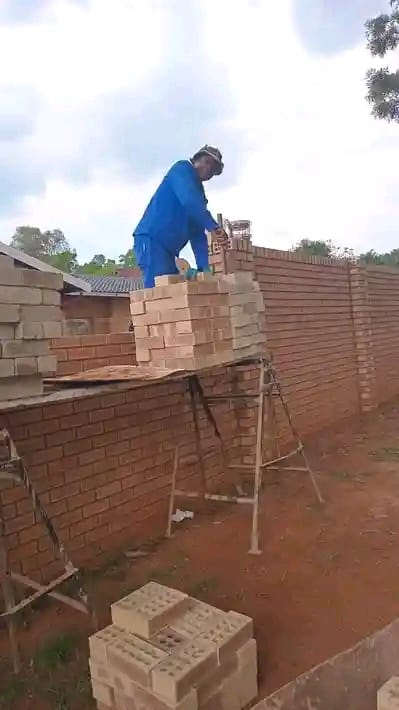 Bricklayer building a boundary wall on a Phuda Construction site